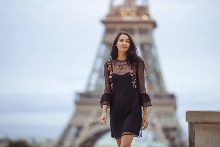 Mujer vestida de forma elegante caminando por París con la Torre Eiffel de fondo.
